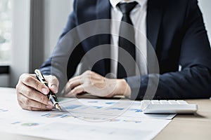 Businessman sits in a private office at his company and is reviewing company financial documents, senior management checking