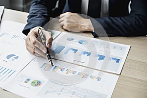 Businessman sits in a private office at his company and is reviewing company financial documents, senior management checking