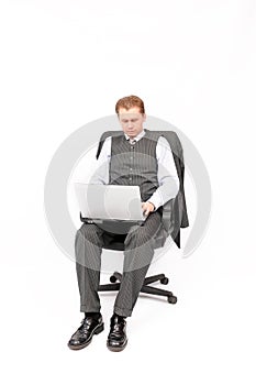Businessman sitting in an armchair with a laptop.