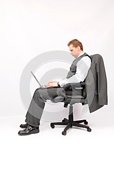 Businessman sitting in an armchair with a laptop.