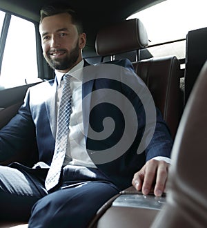 Businessman sitting in the back seat of a car