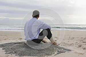 Businessman sitting on the beach