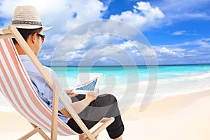 Businessman sitting on beach chairs and look stock financial