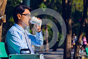 Businessman,He is sitting on bench in park.He is thinking about business.