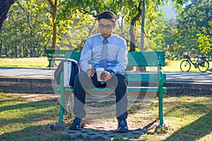 Businessman,He is sitting on bench in park.He is thinking about business.