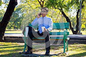 Businessman,He is sitting on bench in park.He is thinking about business.