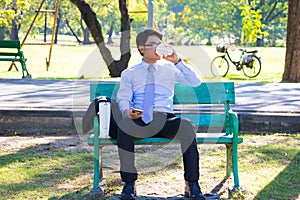 Businessman,He is sitting on bench in park.He is thinking about business.