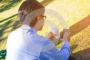 Businessman,He is sitting on bench in park.He is thinking about business.