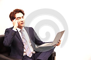 Businessman sitting on the black sofa, thinking making business decision on the internet by laptop computer
