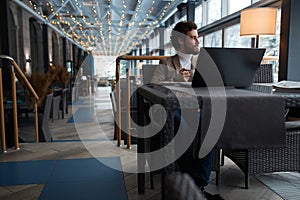 Businessman sitting in cafe and looking at the window