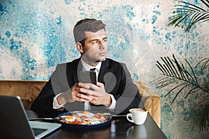 Businessman sitting in cafe using laptop computer have a breakfast or dinner eat using mobile phone