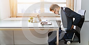 Businessman Sitting On Chair Suffering From Back Pain