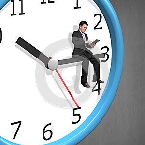 Businessman sitting on clock pointer