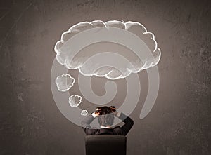 Businessman sitting with cloud thought above his head