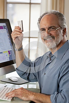 Businessman Sitting at Computer With Credit Card