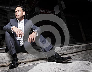 Businessman sitting on the curb