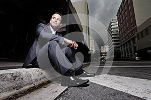 Businessman sitting on the curb