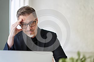 Businessman sitting at desk in office having problem