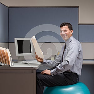 Businessman sitting on exercise ball at desk