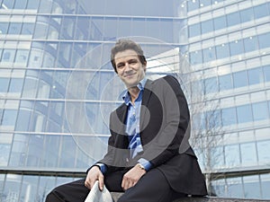 Businessman Sitting In Front Of Office Building