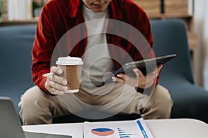 Businessman sitting front tablet ,laptop computer with financial graphs and statistics on monitor.at office