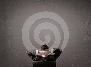 Businessman sitting in front of a wall with copy space