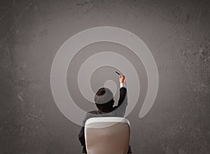 Businessman sitting in front of a wall with copy space