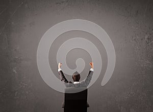 Businessman sitting in front of a wall with copy space