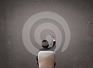 Businessman sitting in front of a wall with copy space