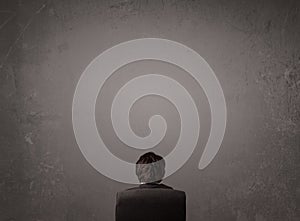 Businessman sitting in front of a wall with copy space