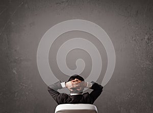 Businessman sitting in front of a wall with copy space