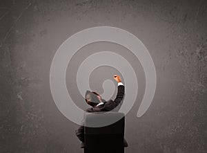 Businessman sitting in front of a wall with copy space