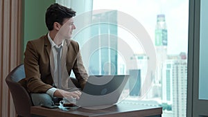 Businessman sitting on furniture working on laptop at ornamented corporate