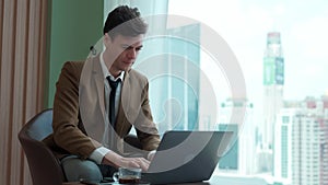 Businessman sitting on furniture working on laptop at ornamented corporate