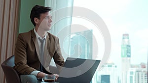 Businessman sitting on furniture working on laptop at ornamented corporate