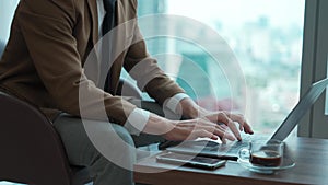 Businessman sitting on furniture working on laptop at ornamented corporate