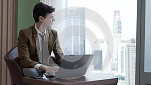 Businessman sitting on furniture working on laptop at ornamented corporate