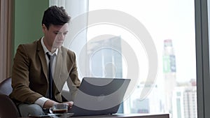 Businessman sitting on furniture working on laptop at ornamented corporate