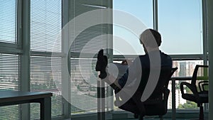 Businessman is sitting with his feet on the table in the office