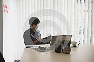 Businessman sitting in his office room and checking reports.
