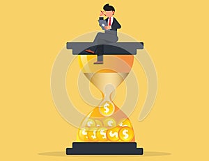Businessman sitting on an hourglass and working. describe time is money