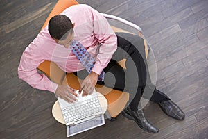 Businessman sitting indoors with laptop