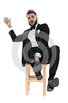 Businessman sitting and leaning back while grabbing the chair scared