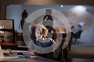 Businessman sitting with legs on desk at office