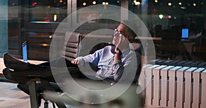 Businessman sitting with legs on desk at office