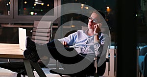 Businessman sitting with legs on desk at office