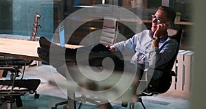 Businessman sitting with legs on desk at office