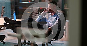 Businessman sitting with legs on desk at office