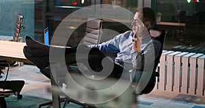 Businessman sitting with legs on desk at office