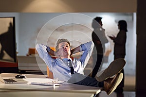 Businessman sitting with legs on desk at office